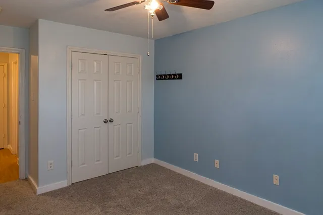 an empty room with a chandelier fan
