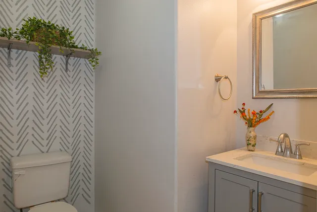 a bathroom with a sink and mirror with bathtub