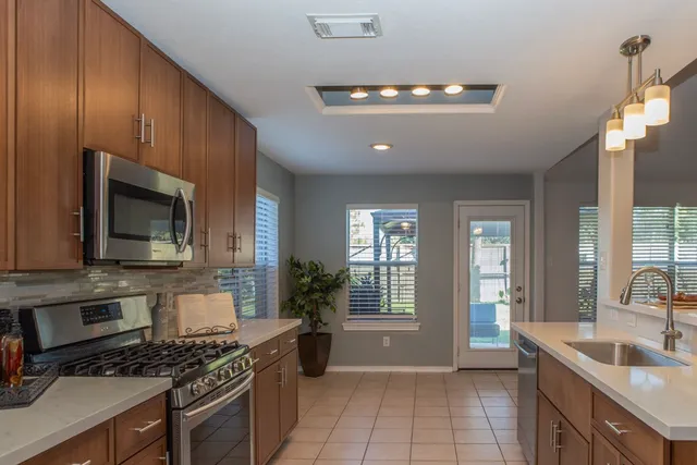 a kitchen with sink a microwave and cabinets