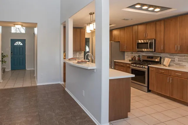 a kitchen with kitchen island granite countertop a sink stove and refrigerator