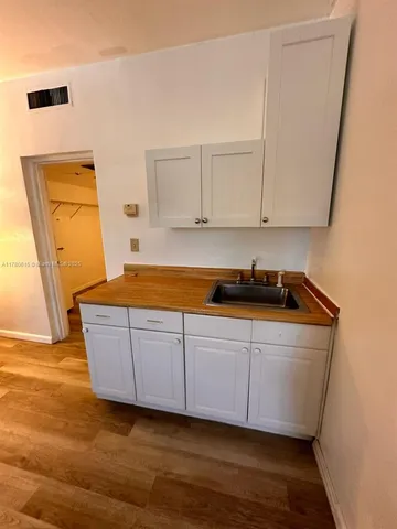a room with wooden floor and cabinets