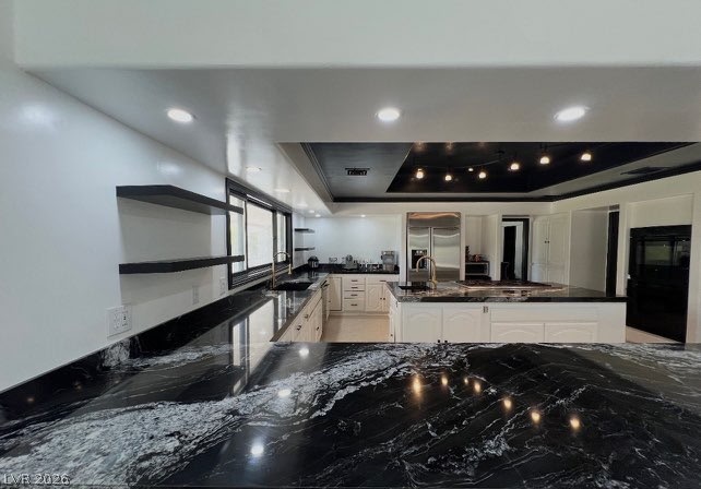3003 Regency Hill Henderson, NV 89014 - Photo 4 of 13 Black granite countertops and open shelving create a dramatic and functional kitchen space.