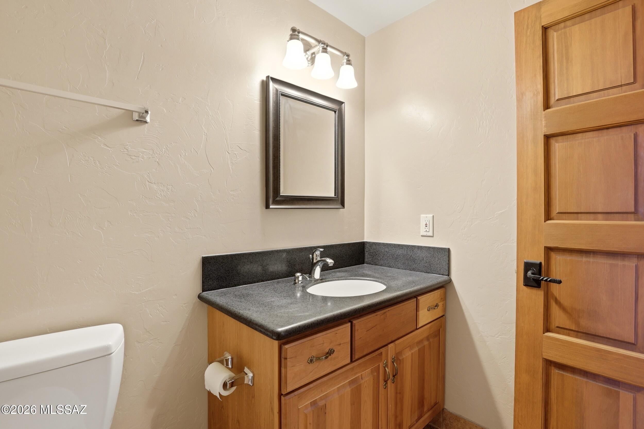6331 West Trails End Road Tucson, AZ 85745 - Photo 28 of 41 a bathroom with a sink toilet and mirror
