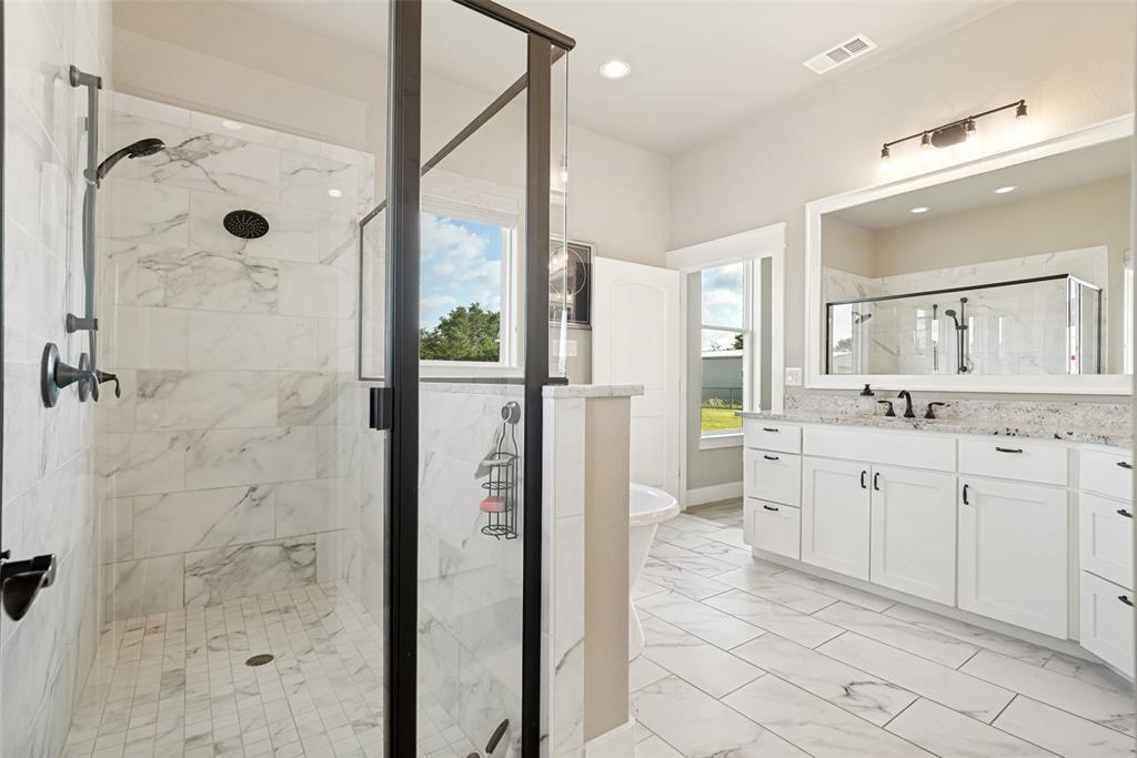 6913 Veal Station Road Weatherford, TX 76085 - Photo 18 of 31 Spacious bathroom featuring a frameless glass shower enclosure with matte black trim, a rainfall showerhead, and a handheld spray