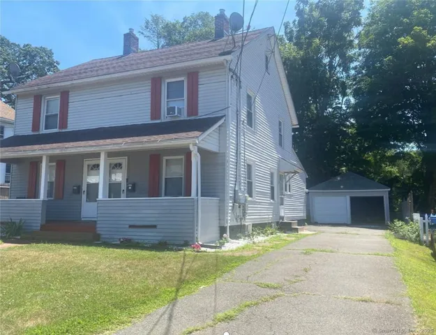 a front view of a house with a garden and yard