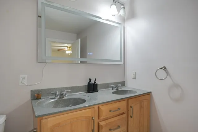 a bathroom with a sink double vanity and granite