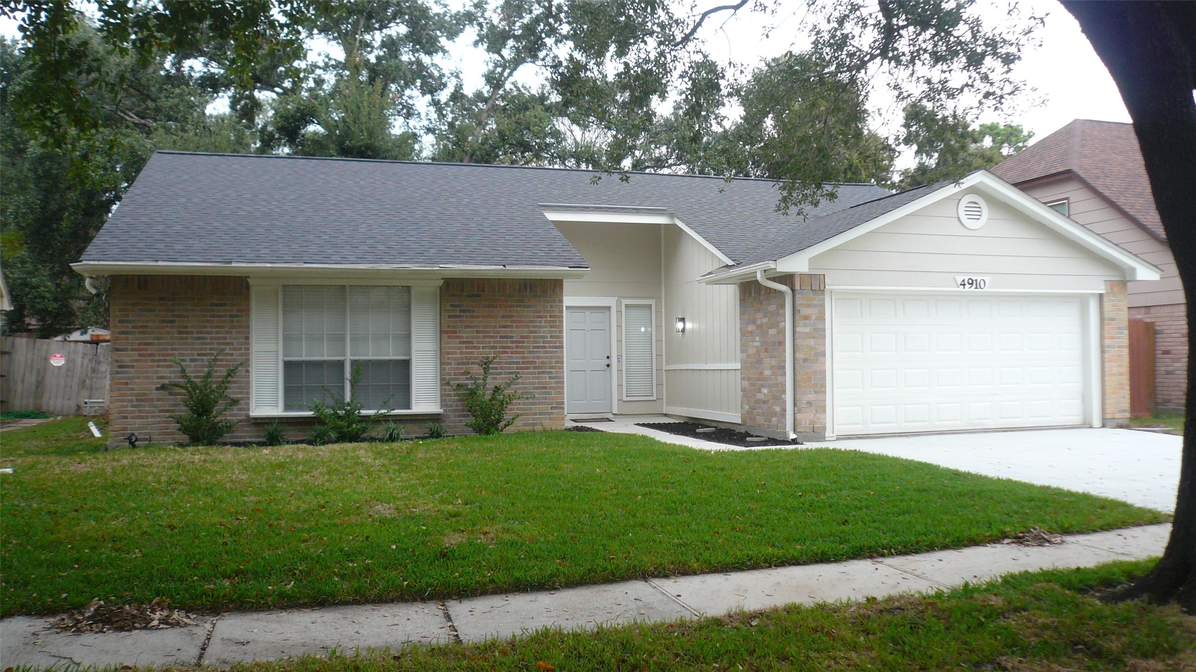 a front view of a house with a garden and yard