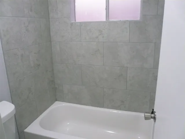 a bathroom with a white bath tub and a shower