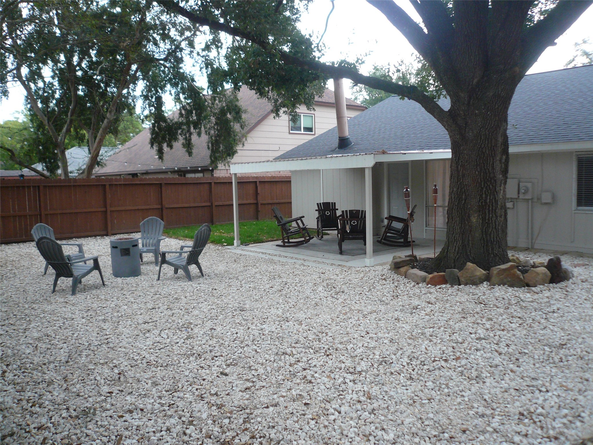 4910 Hennington Drive Spring, TX 77388 - Photo 17 of 18 a view of a patio with table and chairs under an umbrella with large trees