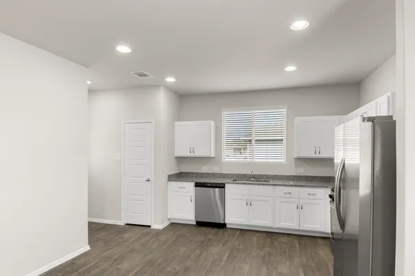 a kitchen with stainless steel appliances granite countertop a refrigerator and a stove top oven