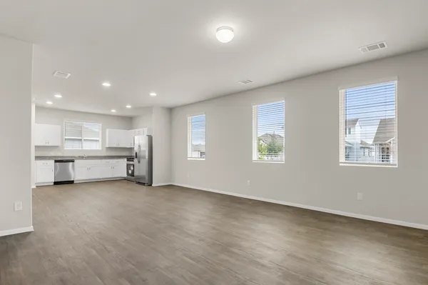 an empty room with windows and cabinet area