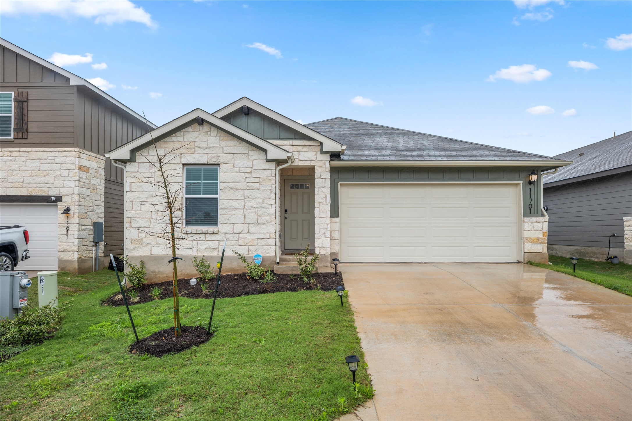 11701 Copperstone Avenue Austin, TX 78748 - Photo 2 of 29 View of front of home with stone siding, driveway, a garage, board and batten siding, and a front lawn