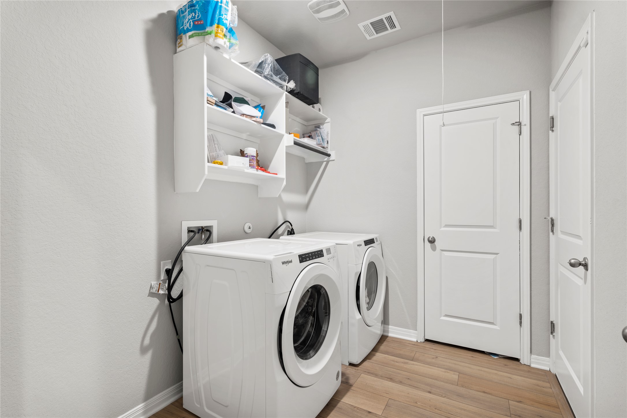 11701 Copperstone Avenue Austin, TX 78748 - Photo 20 of 29 Laundry area with light wood finished floors and washing machine and clothes dryer