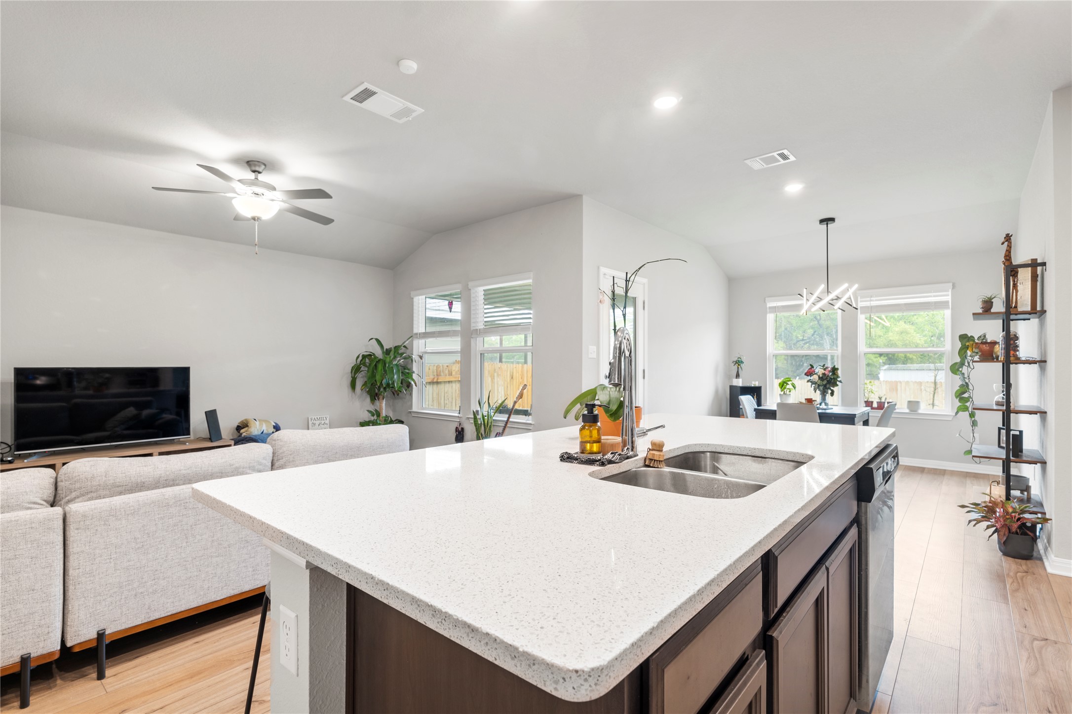 11701 Copperstone Avenue Austin, TX 78748 - Photo 29 of 29 Kitchen with lofted ceiling, a center island with sink, open floor plan, light wood-style flooring, and light stone counters