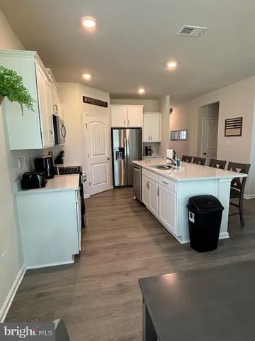 a large kitchen with stainless steel appliances granite countertop a sink a stove and a refrigerator