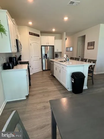 a kitchen with kitchen island a dining table and chairs