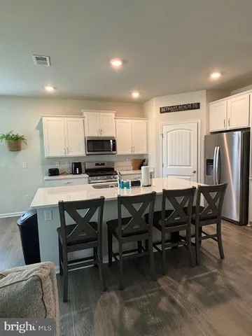 a kitchen with white cabinets and black appliances