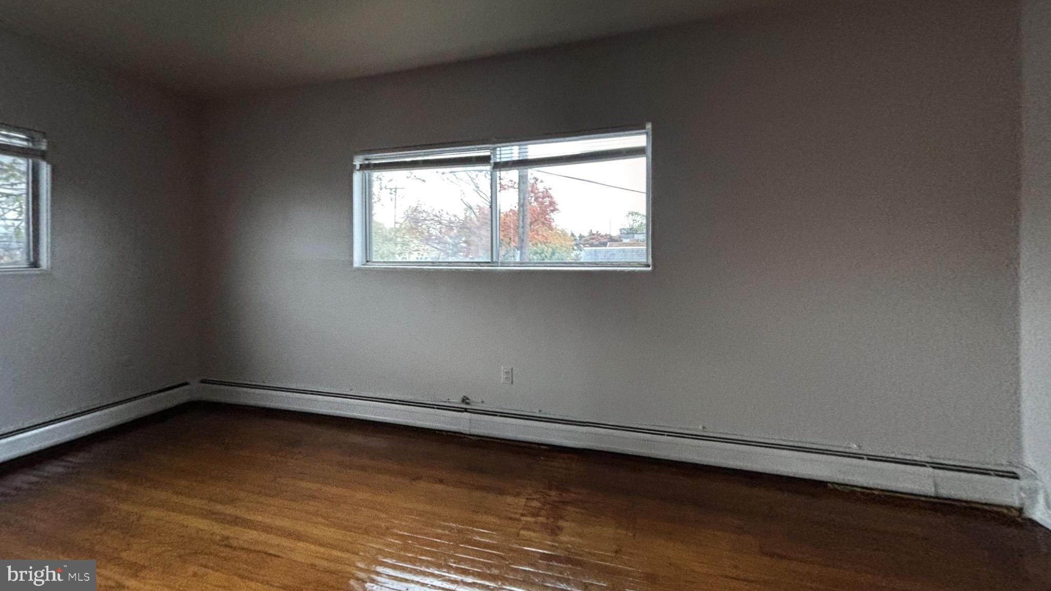 1606 Rhawn Street, Unit 4 Philadelphia, PA 19111 - Photo 2 of 4 an empty room with wooden floor and windows