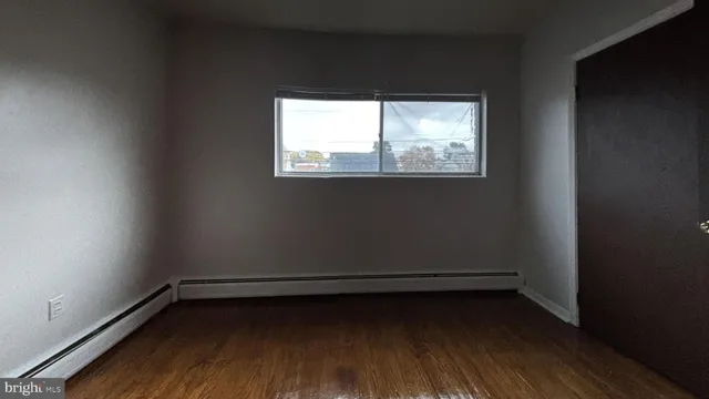 a view of a room with wooden floor and a window