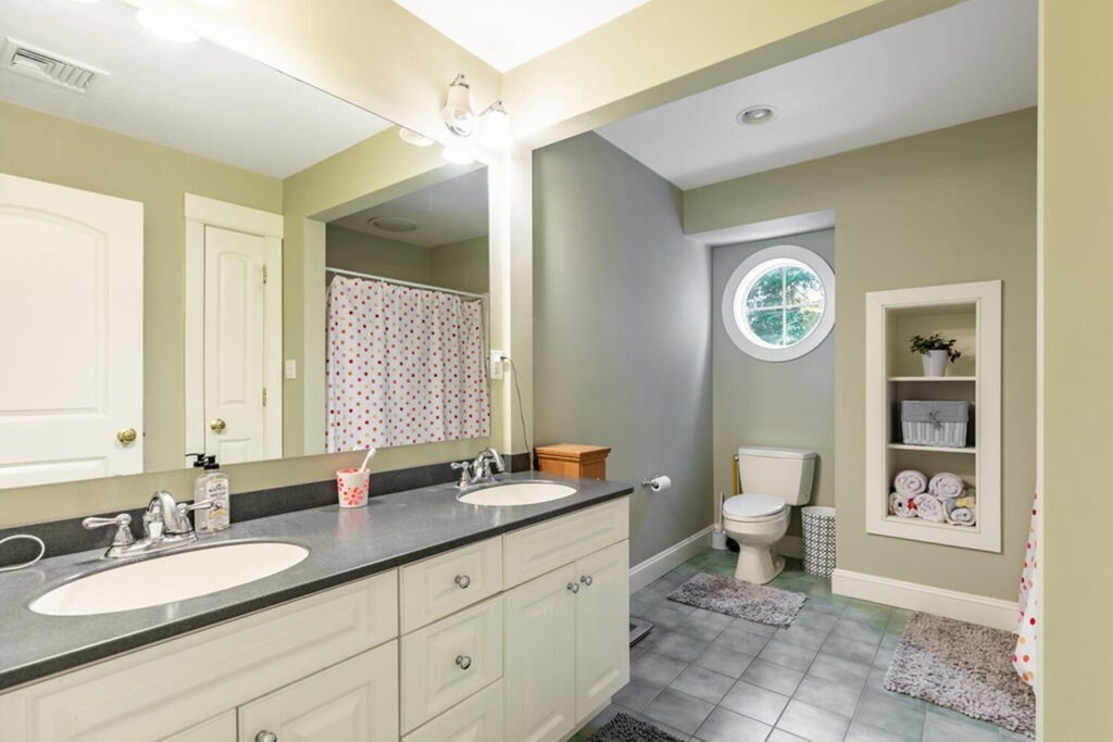 101 Clarke Circle Needham, MA 02492 - Photo 19 of 31 a spacious bathroom with a granite countertop sink toilet and a mirror