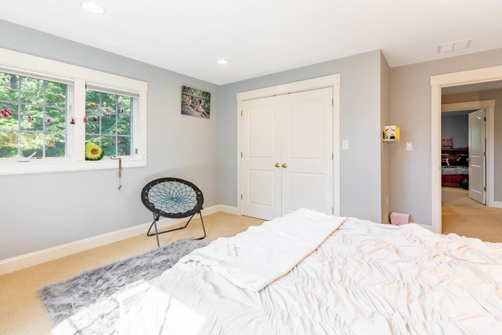 101 Clarke Circle Needham, MA 02492 - Photo 20 of 31 a bedroom with a bed and a chandelier