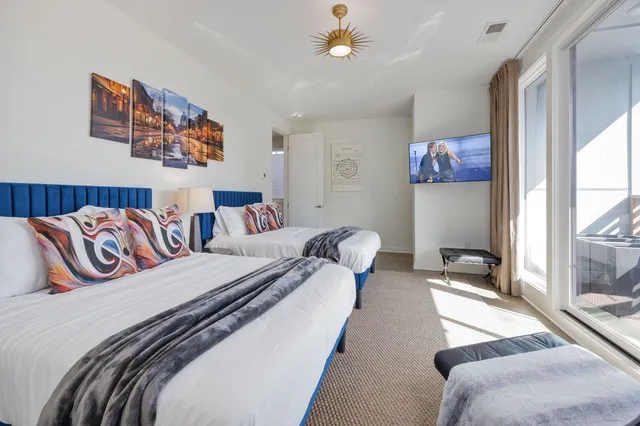 a bedroom with two beds and painting on the wall