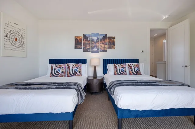 a bedroom with a bed and a lamp on dresser