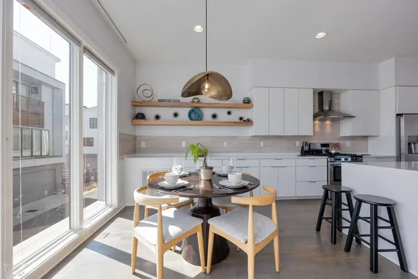 a kitchen with stainless steel appliances kitchen island granite countertop a table and chairs in it