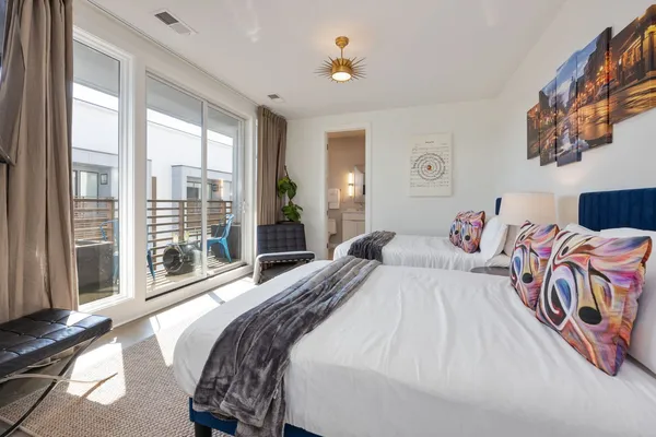 a bedroom with a bed and a large window with balcony view