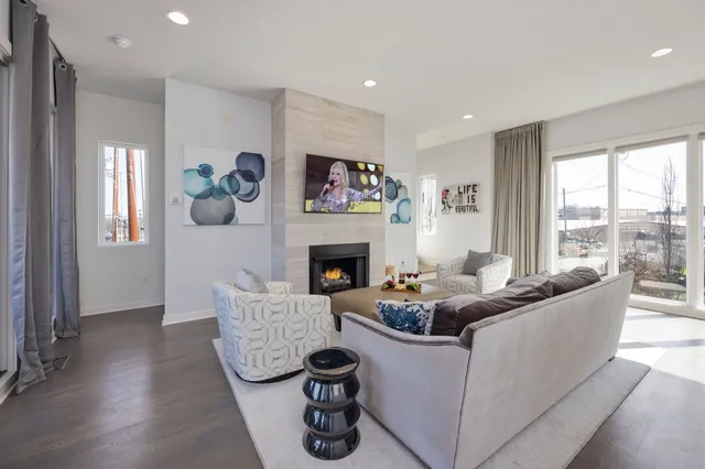 a living room with furniture a fireplace and a large window
