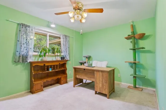 a view of a workspace with furniture and a window