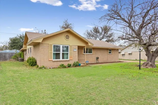 a front view of a house with a garden and yard