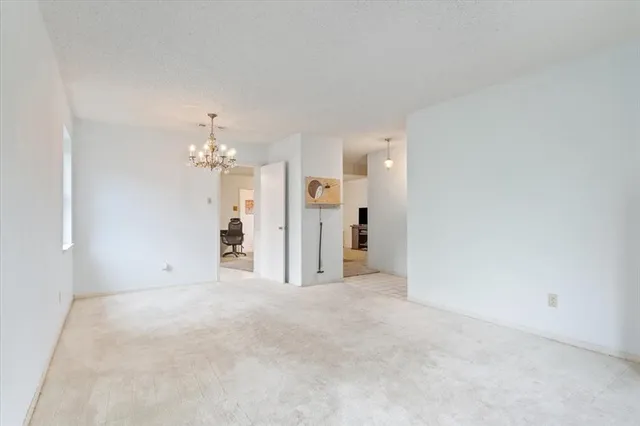 a view of a big room with chandelier fan and windows