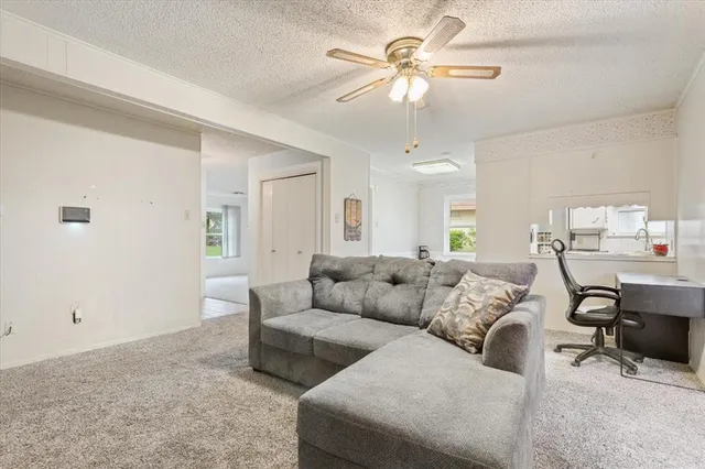a living room with furniture and a ceiling fan