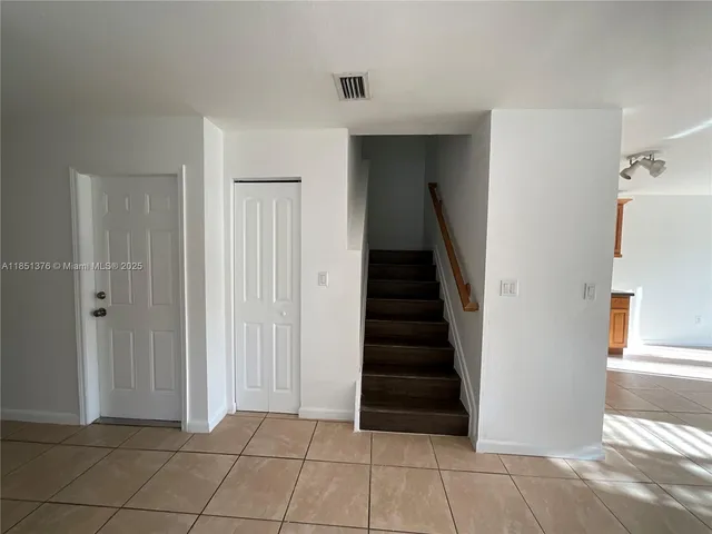 a view of a room that has a large window and front door
