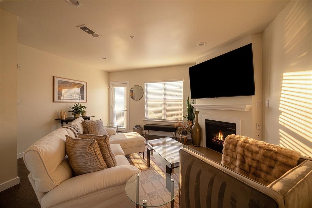 3922 Gilbert Avenue, Unit 214 Dallas, TX 75219 - Photo 9 of 27 Living area featuring a fireplace with a white mantel, recessed lighting, and wood-finish flooring