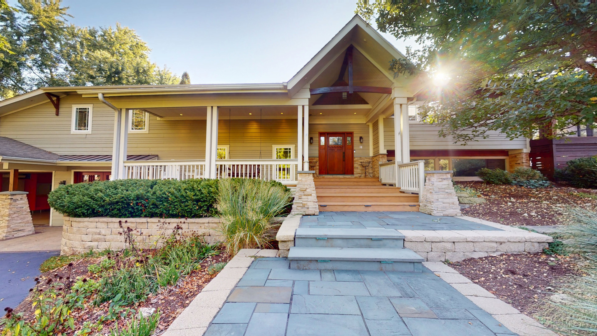 a view of a house with entrance stairs and a garden