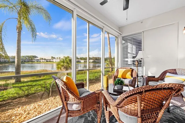 a living room with furniture and floor to ceiling windows