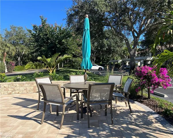 a view of a patio with a bench and trees
