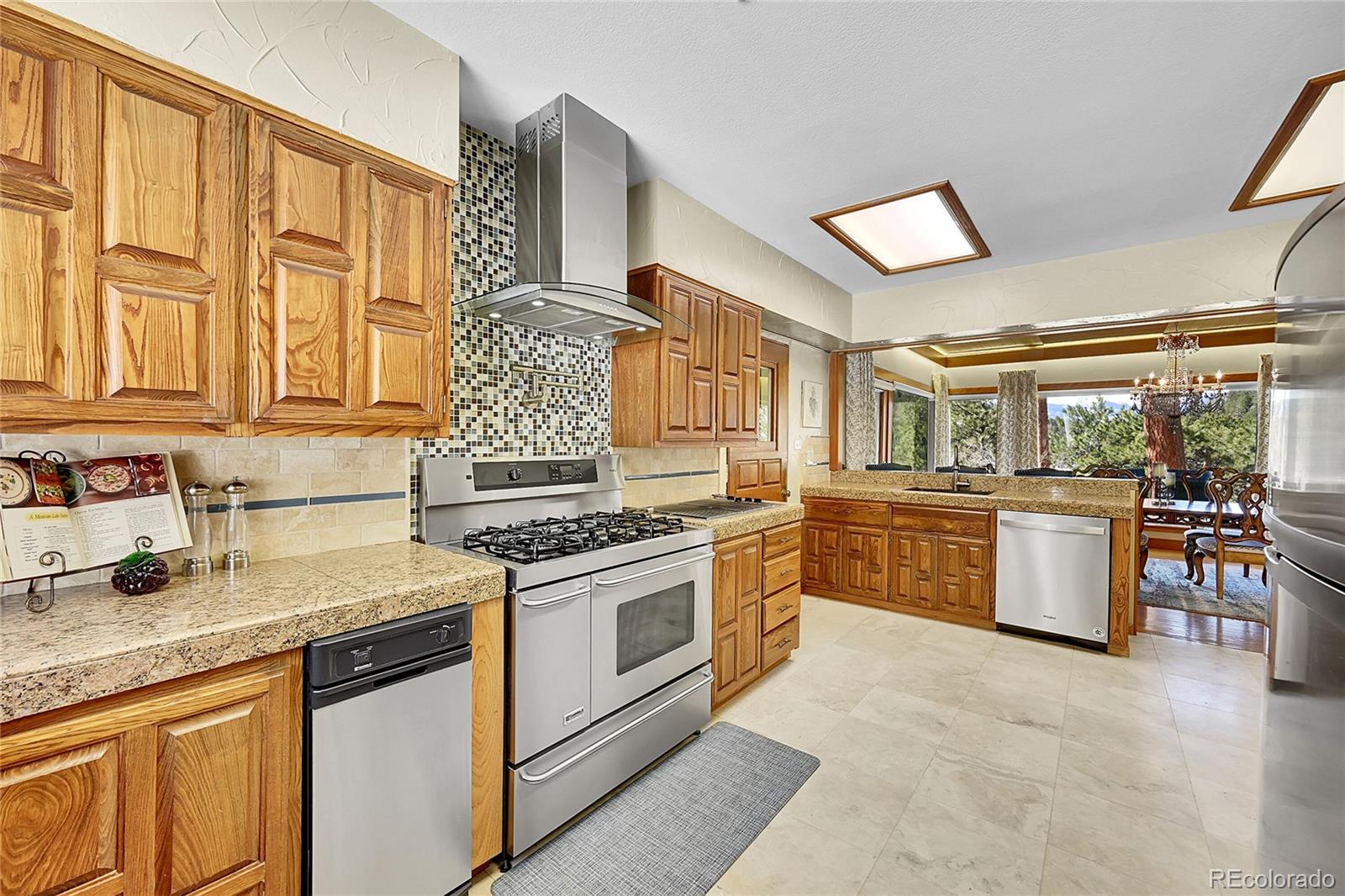 31453 Upper Bear Creek Road Evergreen, CO 80439 - Photo 14 of 22 a kitchen with stainless steel appliances granite countertop a stove and a sink