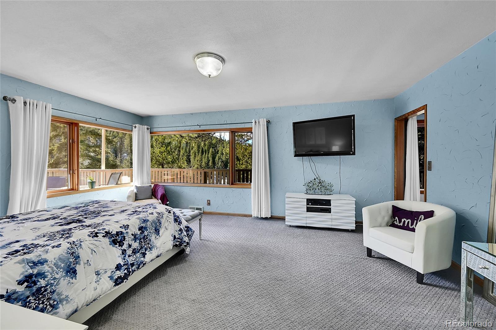 31453 Upper Bear Creek Road Evergreen, CO 80439 - Photo 17 of 22 a bedroom with a bed and a flat screen television