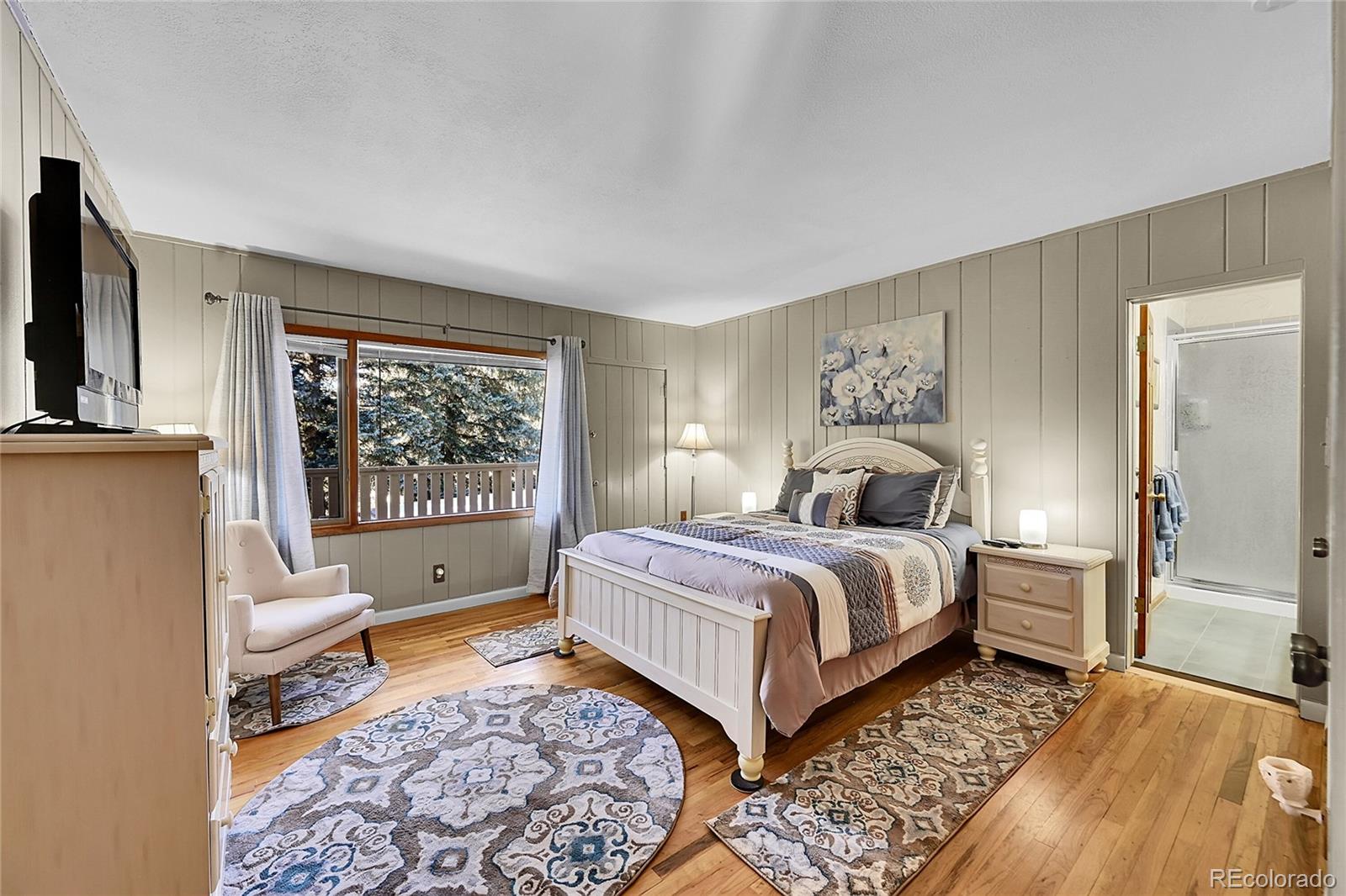 31453 Upper Bear Creek Road Evergreen, CO 80439 - Photo 18 of 22 a spacious bedroom with a bed and glass door