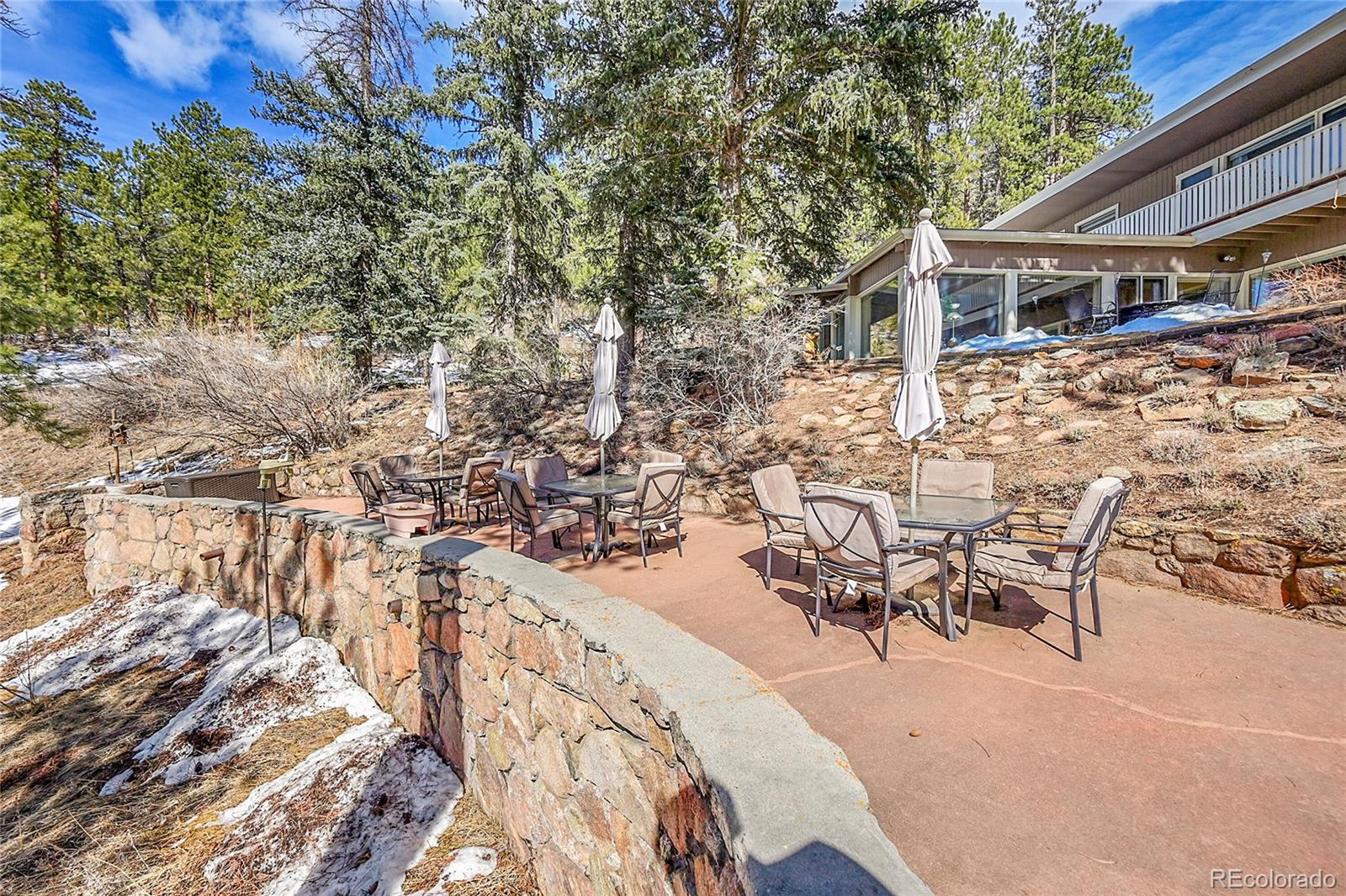 31453 Upper Bear Creek Road Evergreen, CO 80439 - Photo 10 of 22 a view of a patio with table and chairs and wooden floor