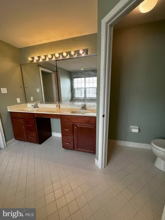 a spacious bathroom with a granite countertop sink a mirror and a bathtub