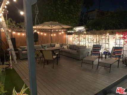 a patio with tables and chairs with wooden floor