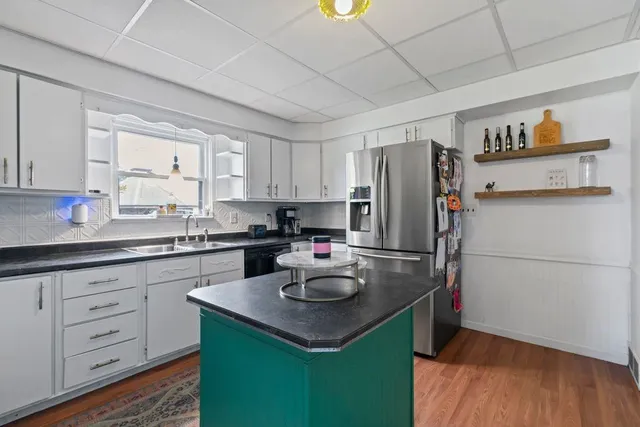 a kitchen with refrigerator and white cabinets