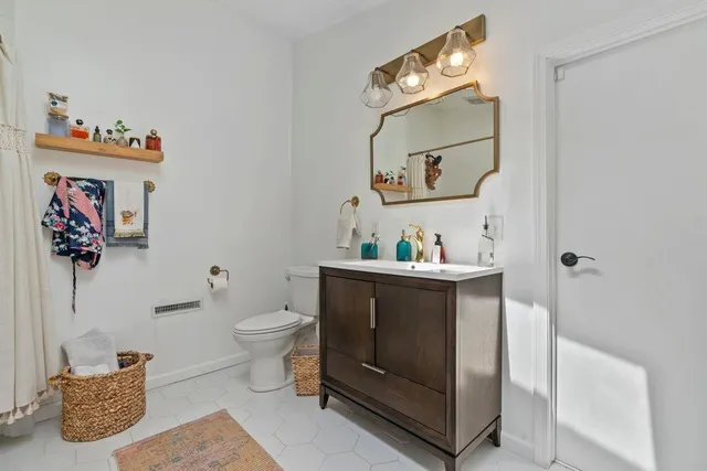a bathroom with a toilet a sink and mirror