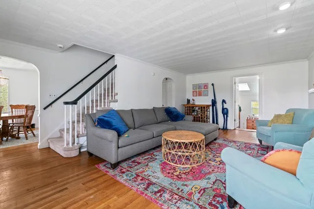 a living room with furniture a rug and a wooden floor