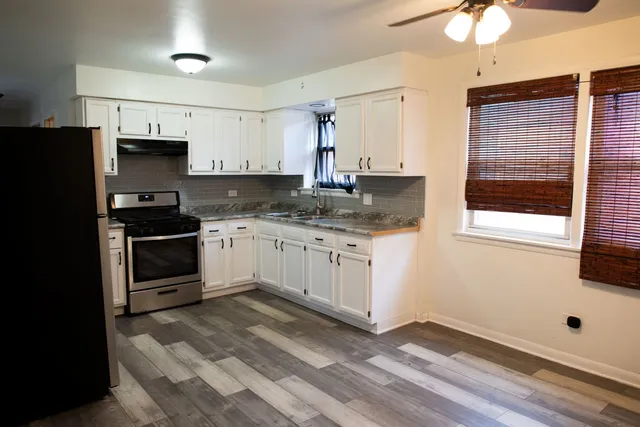 a kitchen with granite countertop white cabinets and white appliances