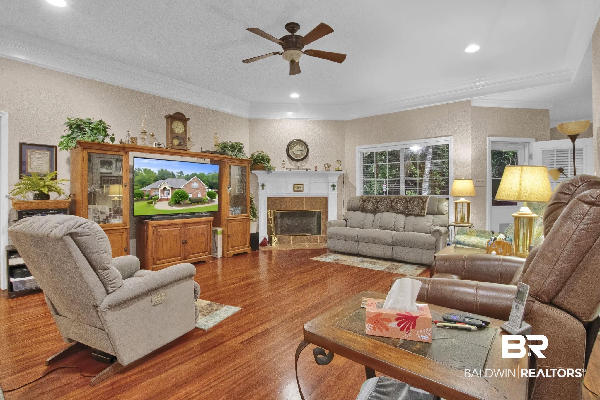 1 Bens Bluff Daphne, AL 36527 - Photo 10 of 56 Living room with a tiled fireplace, crown molding, hardwood / wood-style floors, and ceiling fan